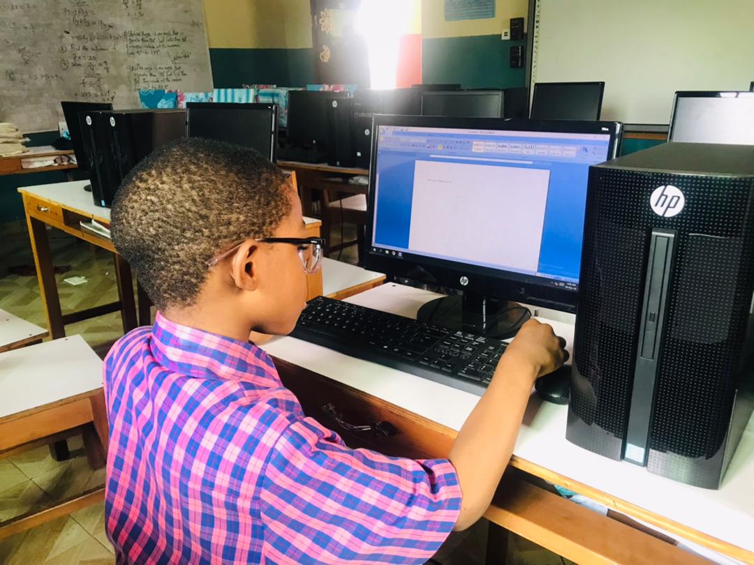 A pupil at MaryVincent Excellent School using the computer